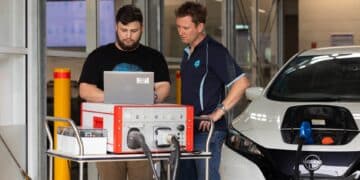 Engineers at CSIRO's Renewable Energy Infrastructure Facility configuring a vehicle-to-home (V2H) experiment. Image: CSIRO